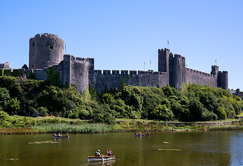 Pembrokeshire castle and the lake with people in row boats)